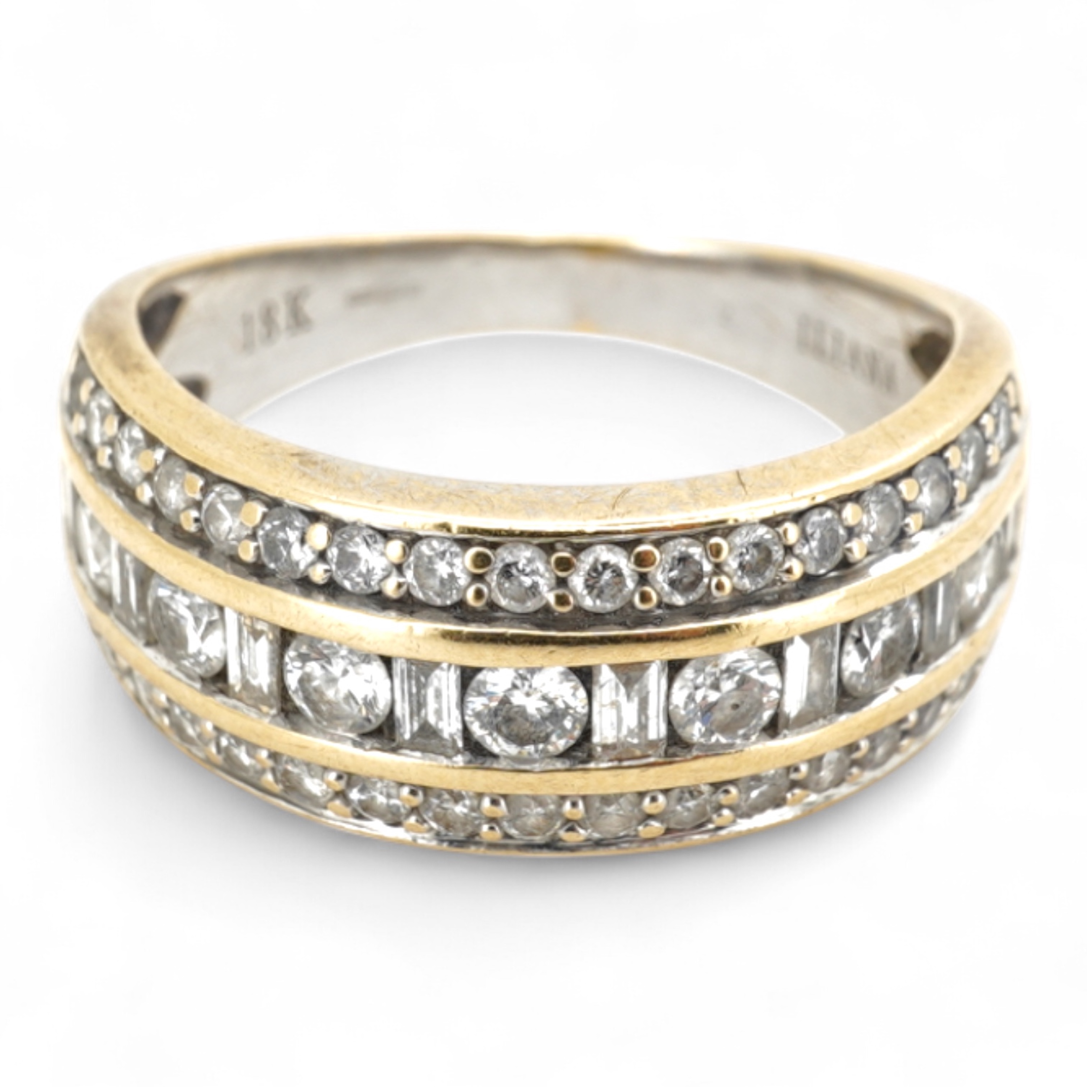 A diamond ring, the wide band set with a line of alternating brilliant-cut and baguette diamonds, between bands of brilliant-cut diamonds, mounted in gold, size M, British hallmarks for 18ct gold, total diamond weight ap